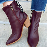 Garnet faux leather pointed toe ankle boot with stacked heel, inner side zipper, and lace-up back detail.