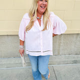 Solid pink button-down blouse with circular eyelet trim, ¾ sleeves, and pleated details, styled for a refined, feminine look.