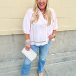 Solid pink button-down blouse with circular eyelet trim, ¾ sleeves, and pleated details, styled for a refined, feminine look.