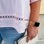 Solid pink button-down blouse with circular eyelet trim, ¾ sleeves, and pleated details, styled for a refined, feminine look.