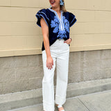 Navy embroidered flutter sleeve top with multicolor appliqué and V-neckline—lightweight and versatile for everyday wear