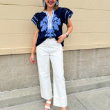 Navy embroidered flutter sleeve top with multicolor appliqué and V-neckline—lightweight and versatile for everyday wear
