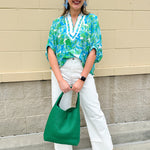White caftan top with green and blue abstract floral print, split neckline, and dolman sleeves with elastic cuffs—lightweight and flowy