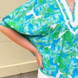 White caftan top with green and blue abstract floral print, split neckline, and dolman sleeves with elastic cuffs—lightweight and flowy