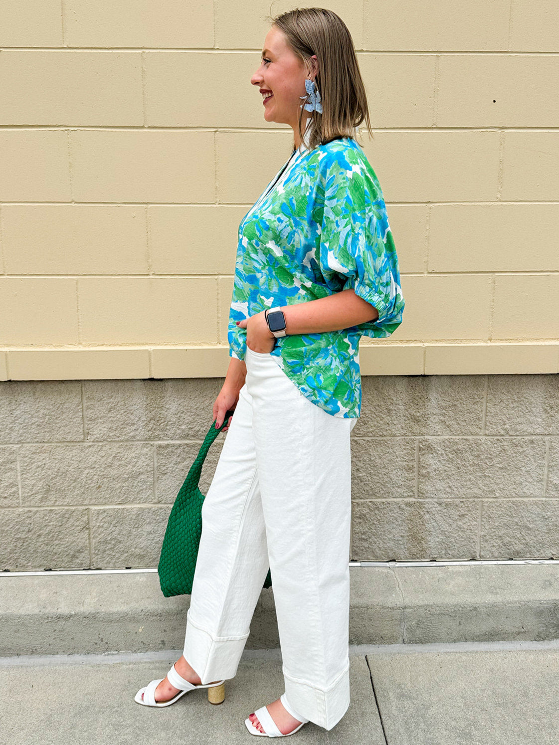 White caftan top with green and blue abstract floral print, split neckline, and dolman sleeves with elastic cuffs—lightweight and flowy