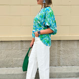 White caftan top with green and blue abstract floral print, split neckline, and dolman sleeves with elastic cuffs—lightweight and flowy
