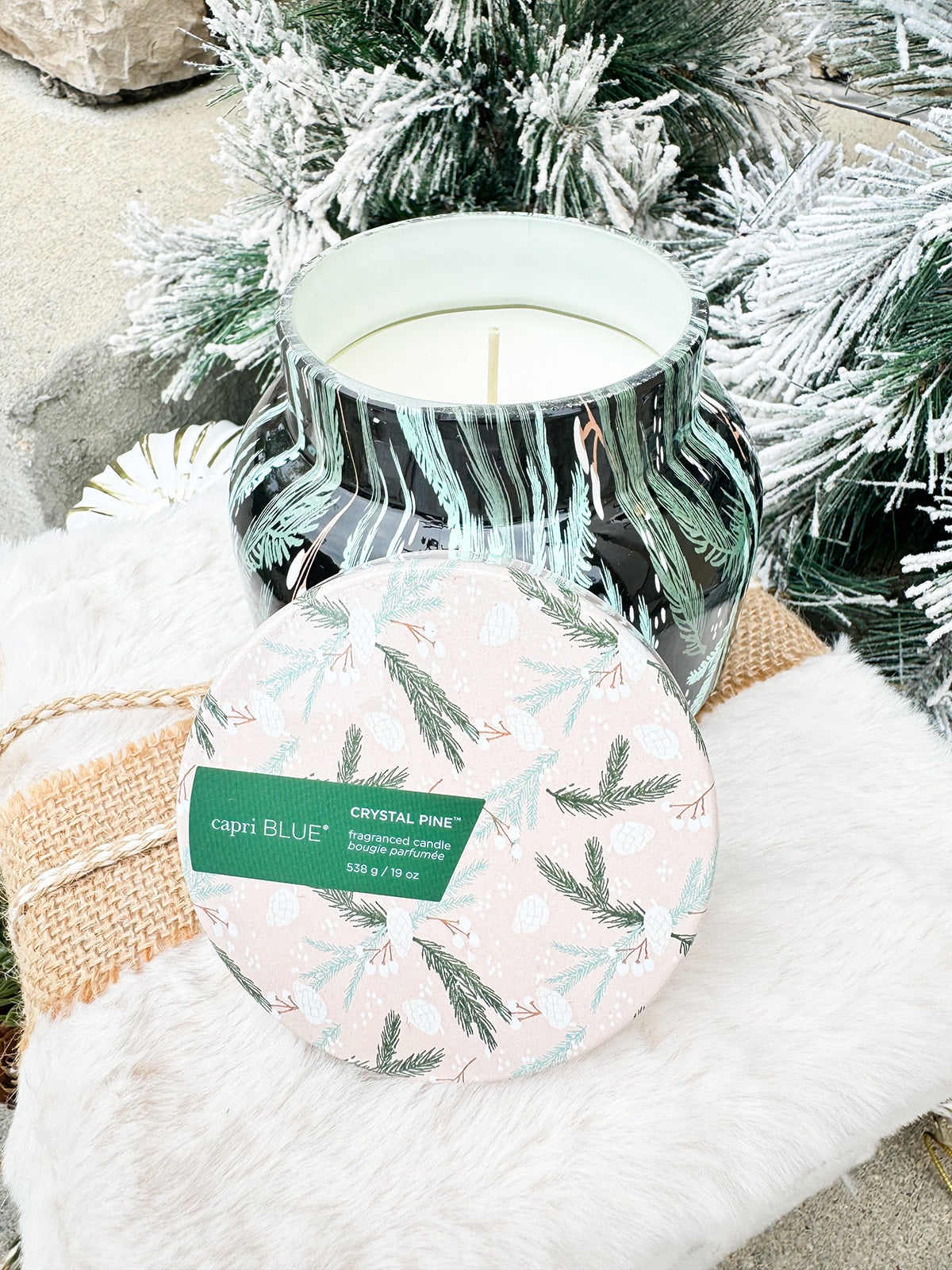 Capri Blue 19oz black candle jar with green and mint fir leaf holiday design, Crystal Pine scent.