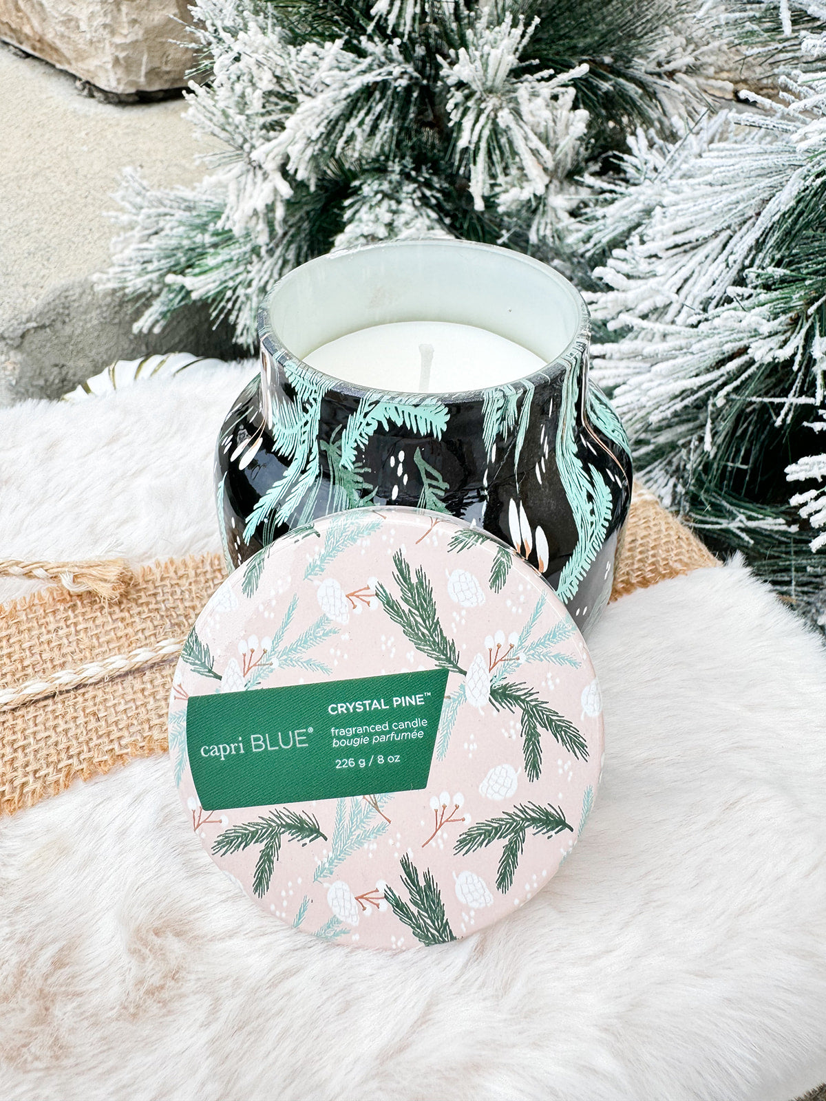 Capri Blue Holiday Pattern Play Crystal Pine Candle in black jar with green and mint fir leaf design.