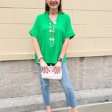 Kelly green blouse with frilled V-neckline, short dolman sleeves, and banded cuffs—bright, stylish, and feminine.