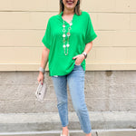 Kelly green blouse with frilled V-neckline, short dolman sleeves, and banded cuffs—bright, stylish, and feminine.