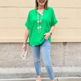 Kelly green blouse with frilled V-neckline, short dolman sleeves, and banded cuffs—bright, stylish, and feminine.