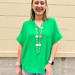 Kelly green blouse with frilled V-neckline, short dolman sleeves, and banded cuffs—bright, stylish, and feminine.
