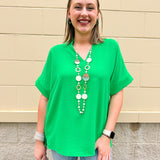 Kelly green blouse with frilled V-neckline, short dolman sleeves, and banded cuffs—bright, stylish, and feminine.
