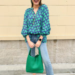 Flowy navy and green patterned blouse with tie-neck, ruffle collar, dolman sleeves, and elastic cuffs—lightweight and oversized