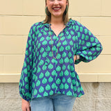 Flowy navy and green patterned blouse with tie-neck, ruffle collar, dolman sleeves, and elastic cuffs—lightweight and oversized