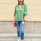 Green and pink paisley print blouse with frilled tie neckline and three-quarter peasant sleeves displayed on hanger against a neutral background