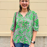 Green and pink paisley print blouse with frilled tie neckline and three-quarter peasant sleeves displayed on hanger against a neutral background