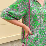 Green and pink paisley print blouse with frilled tie neckline and three-quarter peasant sleeves displayed on hanger against a neutral background