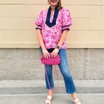 Pink caftan-style top with split neckline and botanical floral print, lightweight and relaxed fit