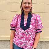 Pink caftan-style top with split neckline and botanical floral print, lightweight and relaxed fit