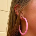 Bright pink 2-inch acrylic hoop earrings—lightweight and bold, perfect for adding a fun pop of color.