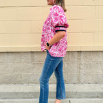 Pink caftan-style top with split neckline and botanical floral print, lightweight and relaxed fit