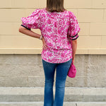 Pink caftan-style top with split neckline and botanical floral print, lightweight and relaxed fit
