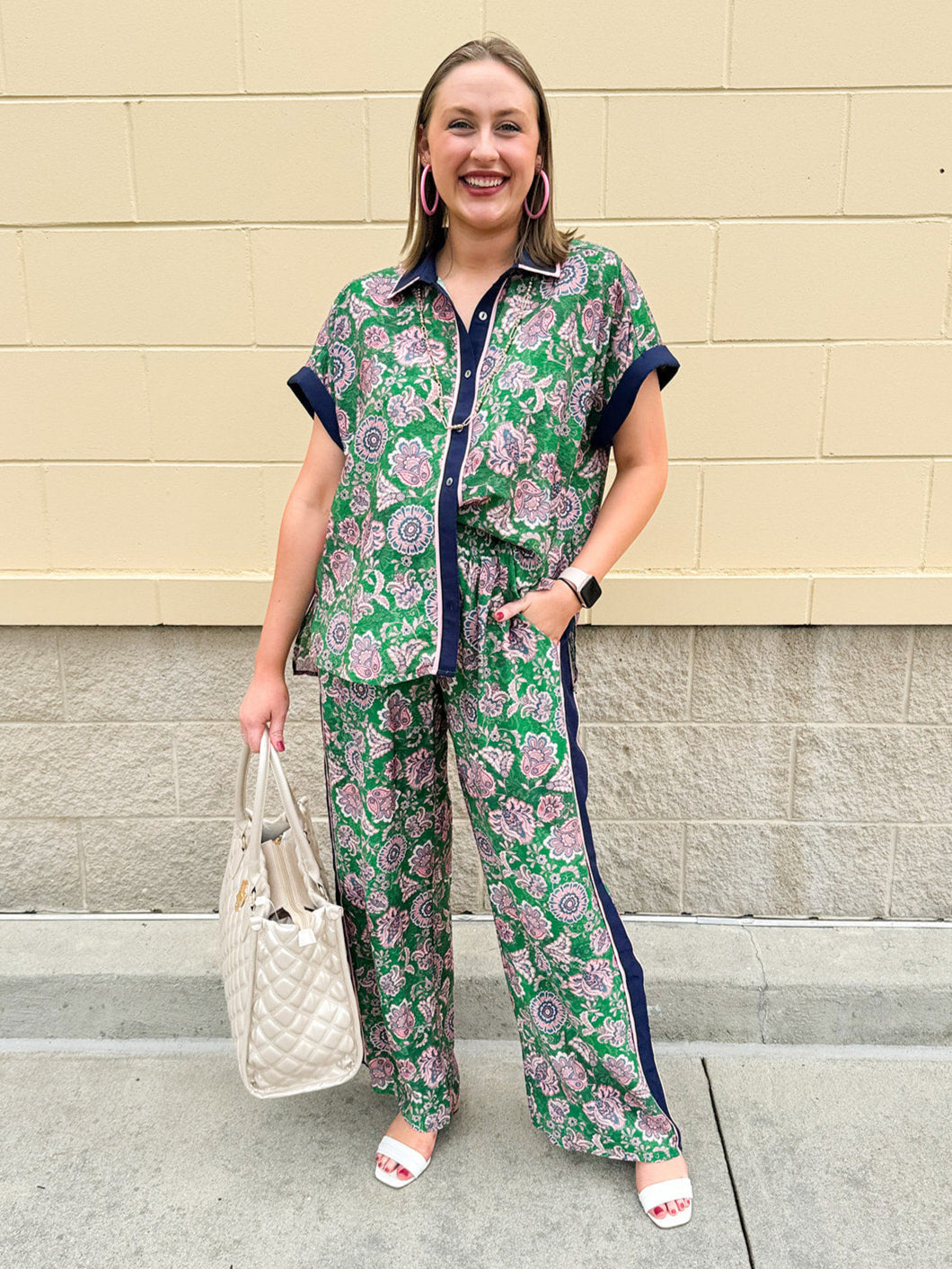 Floral paisley button-down blouse with navy collar, pink trim, high-low hem, and navy-trimmed sleeves—lightweight and chic