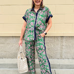 Floral paisley button-down blouse with navy collar, pink trim, high-low hem, and navy-trimmed sleeves—lightweight and chic