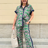 Floral paisley button-down blouse with navy collar, pink trim, high-low hem, and navy-trimmed sleeves—lightweight and chic