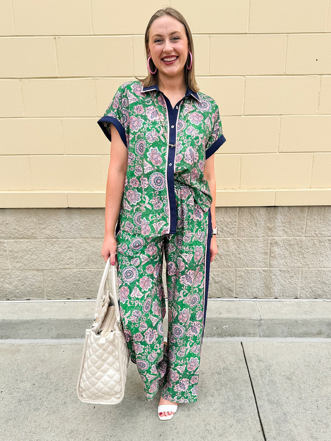 Floral paisley button-down blouse with navy collar, pink trim, high-low hem, and navy-trimmed sleeves—lightweight and chic