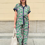 Floral paisley button-down blouse with navy collar, pink trim, high-low hem, and navy-trimmed sleeves—lightweight and chic