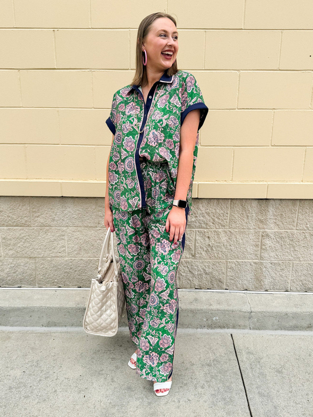 Floral paisley button-down blouse with navy collar, pink trim, high-low hem, and navy-trimmed sleeves—lightweight and chic