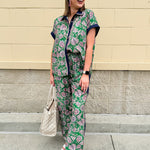Floral paisley button-down blouse with navy collar, pink trim, high-low hem, and navy-trimmed sleeves—lightweight and chic