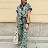 Floral paisley button-down blouse with navy collar, pink trim, high-low hem, and navy-trimmed sleeves—lightweight and chic