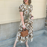 Brown, cream, and olive floral tiered midi dress with short sleeves, button front, and waist tie.