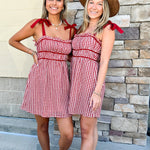Red and white gingham mini dress with adjustable straps and solid trim detail