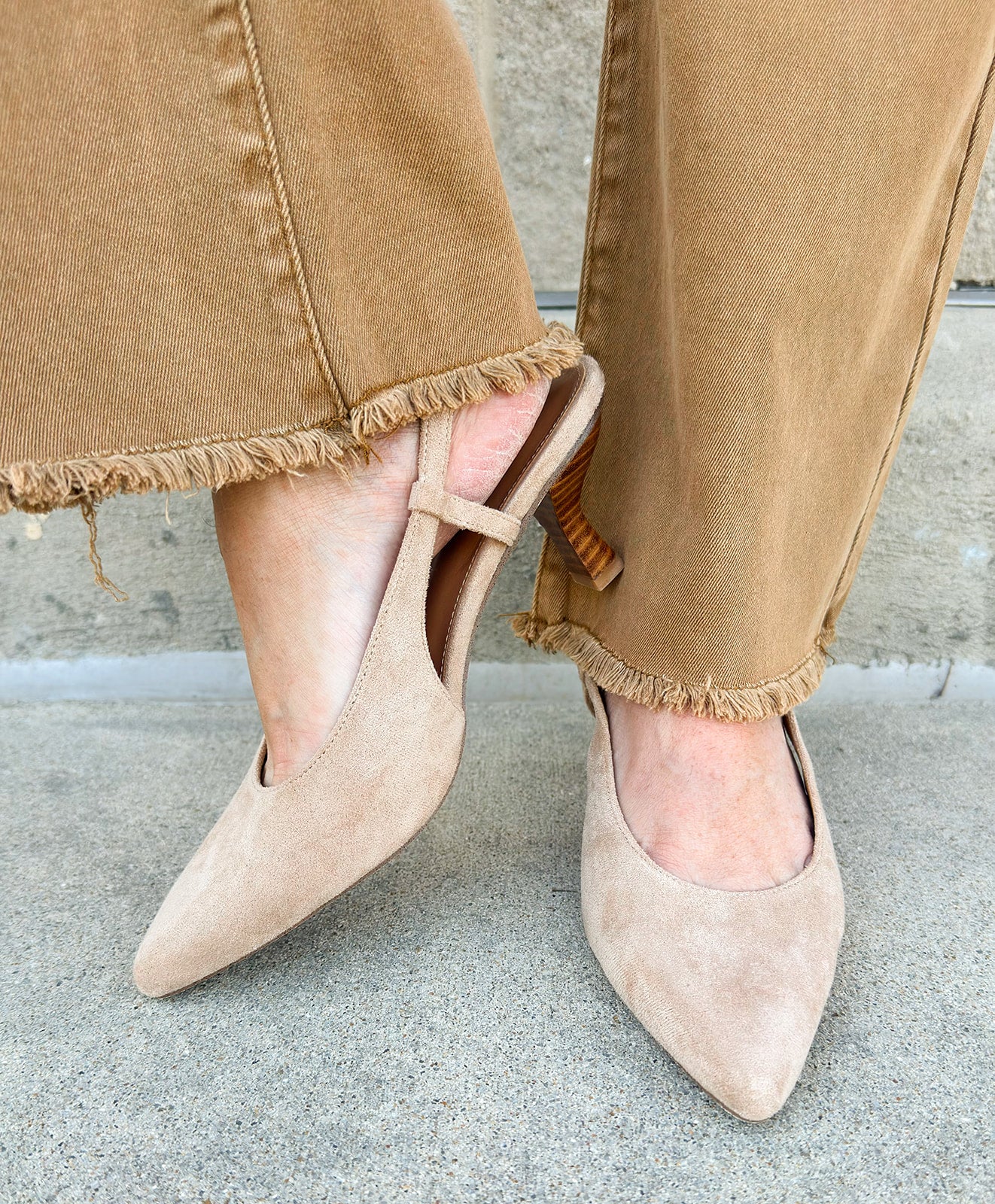 Beige suede slingback pumps with pointed toe and mid stacked heel.