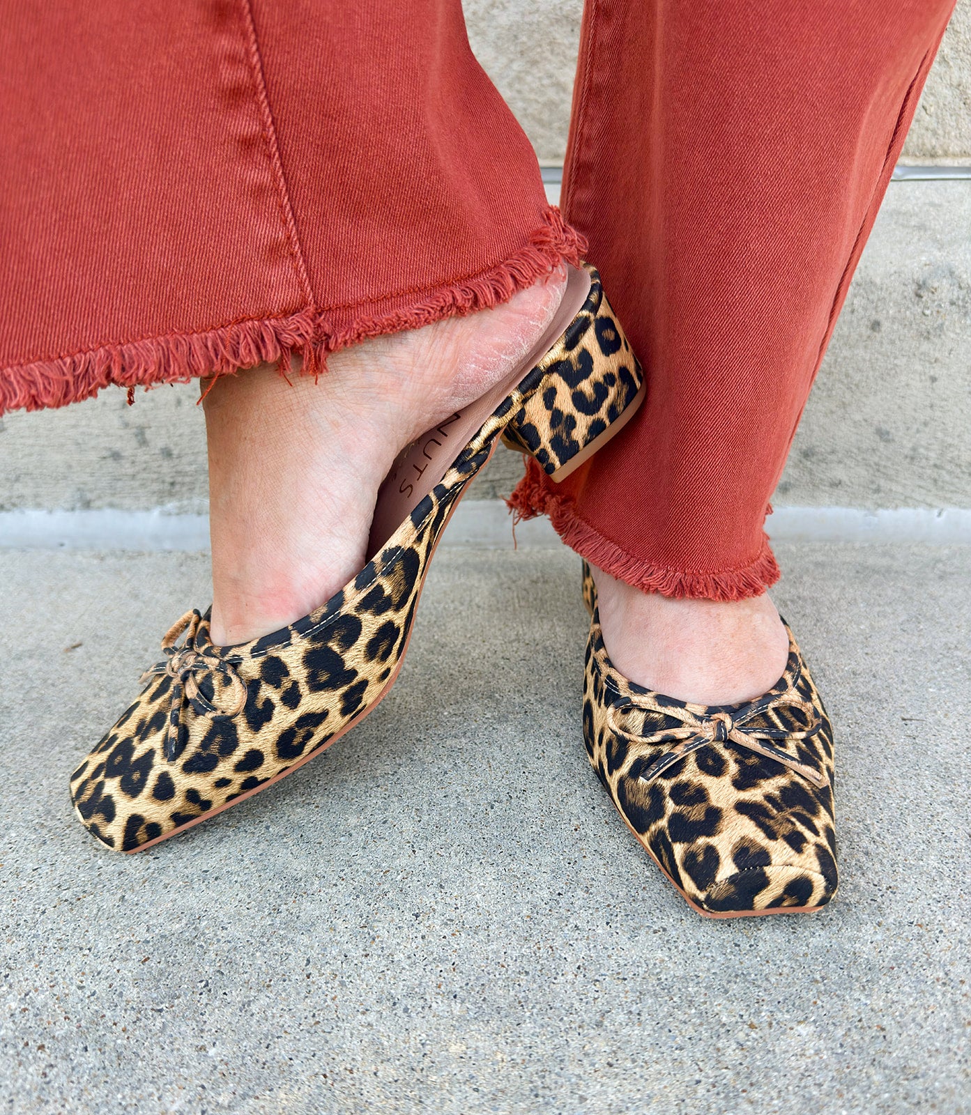 Tan leopard mule with square toe, bow accent, and low block heel.