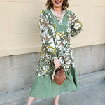Ivory floral tiered midi dress with ruffle collar, contrast bib, and long sleeves.