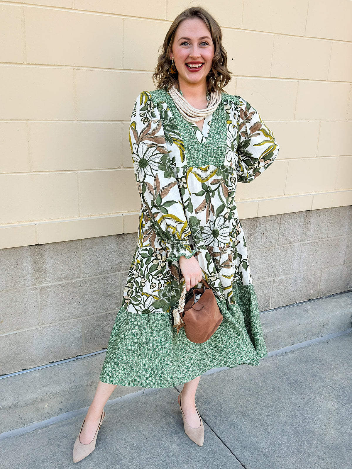 Ivory floral tiered midi dress with ruffle collar, contrast bib, and long sleeves.