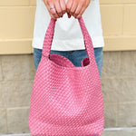 Trendy pink woven handbag with a soft, luxurious texture and modern silhouette—perfect for spring outfits.
