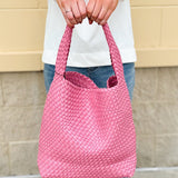 Trendy pink woven handbag with a soft, luxurious texture and modern silhouette—perfect for spring outfits.
