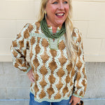Printed V-neck long sleeve blouse with brown, cream, and olive tones, contrasting stripe accents, and decorative trim.