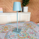 Powder blue Coastal Glow rechargeable cordless table lamp styled on an Imperial Mahjong mat.