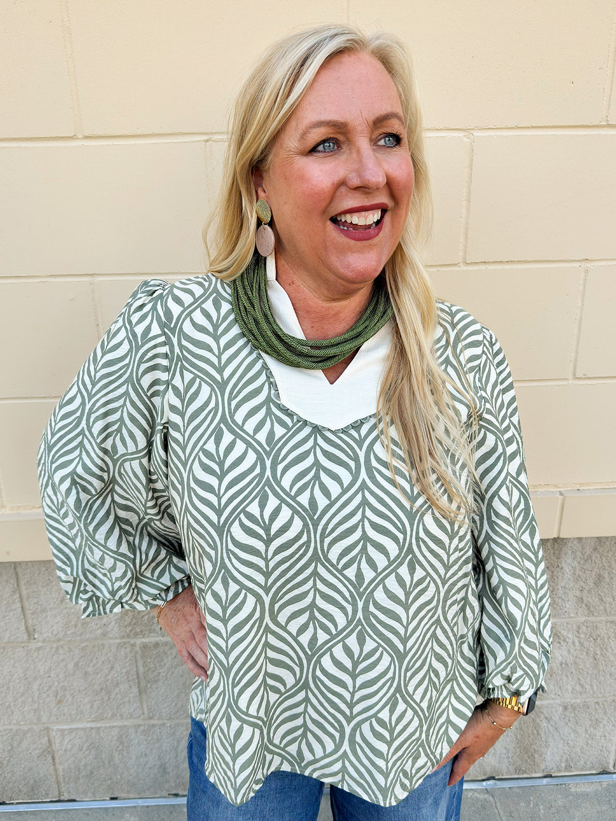 Sage and cream boho leaf print top with 3/4 sleeves, standing collar, lace trim, and solid contrast detail.