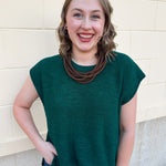 Ash jade short-sleeve lightweight sweater with center seam, rolled cuffs, and side slits.