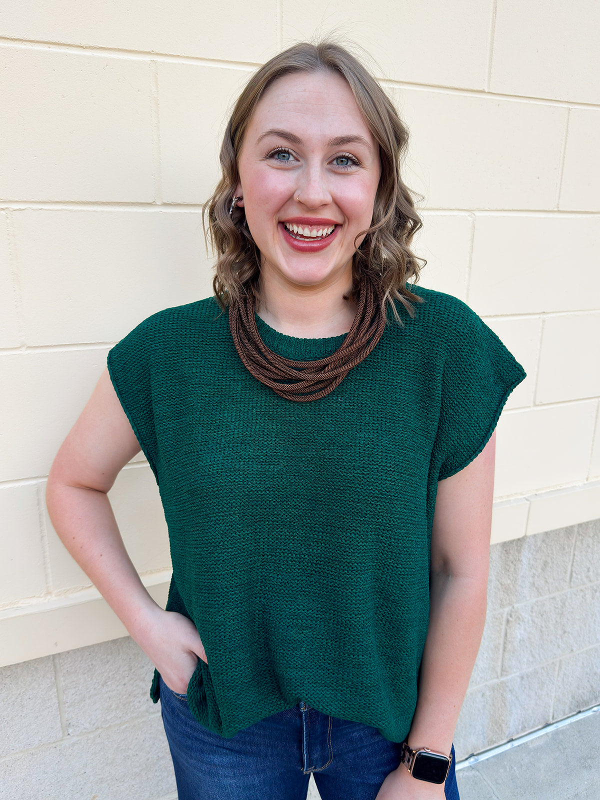 Moss green short-sleeve knit sweater with crew neckline, drop shoulders, and side slits.