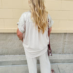 Oatmeal button-down top with gold trim, relaxed fit