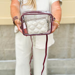 Clear crossbody purse with garnet vegan leather trim and brass hardware, designed for stadium approval and gameday style.